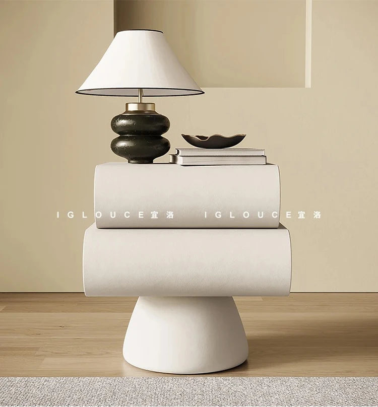 Modern cream bedside table with two rounded storage drawers, supported by a sleek, minimalist pedestal base.