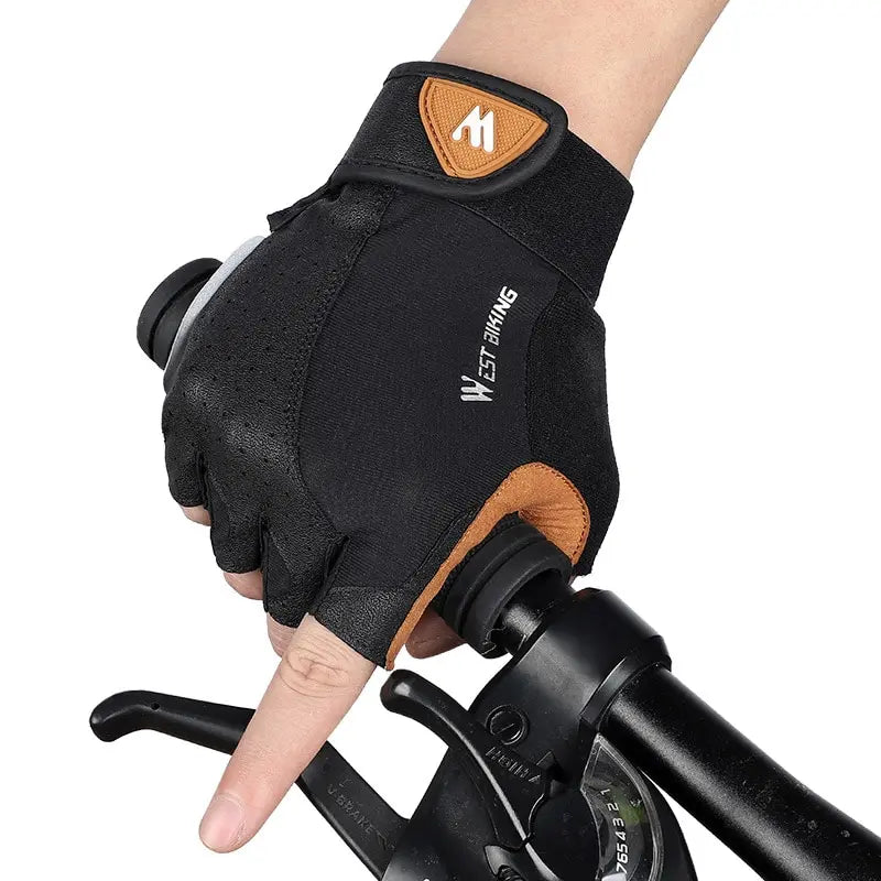 Black and tan West Biking fingerless cycling gloves with a Velcro strap, worn while gripping handlebars.
