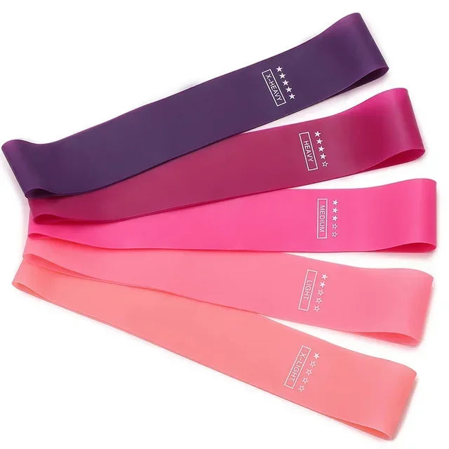 Set of five colourful resistance bands in gradient shades from deep purple to light coral, labelled by intensity.