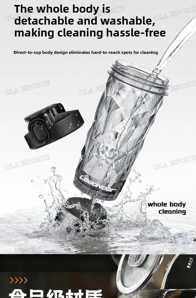 Clear, faceted plastic sports water bottle with a detachable black lid, being washed in water.