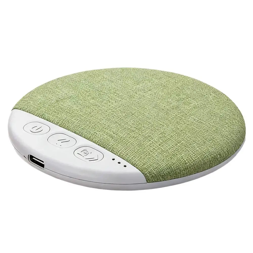 Round, sage-green fabric wireless sleep speaker with a white control panel featuring buttons and a charging port.
