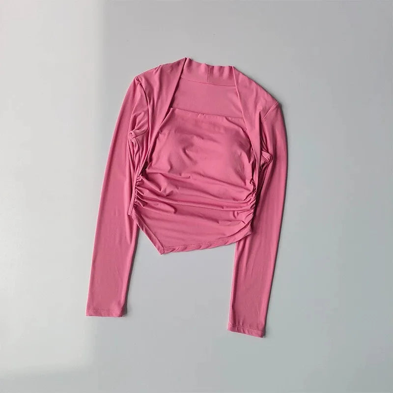 Pink long-sleeve crop top featuring a square neckline, integrated shelf bra, and stylish ruched side detailing.
