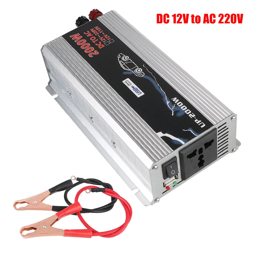 Silver 2000W DC to AC power inverter with USB port, UK socket, power switch, and included battery alligator clip cables.