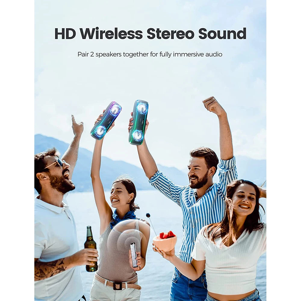 People cheering by the water holding two portable black Bluetooth speakers with vibrant, multi-coloured LED lights.