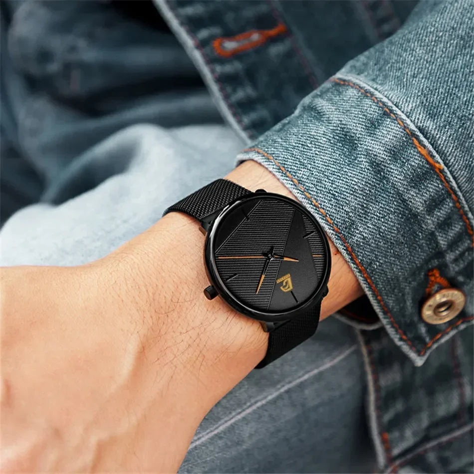 Minimalist men’s ultra-thin quartz watch with a black mesh strap and textured black dial with gold-tone hands.