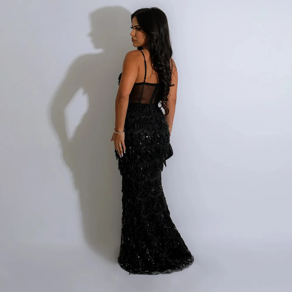 Black sequin maxi evening dress featuring spaghetti straps and a sheer bodice, fitted silhouette.