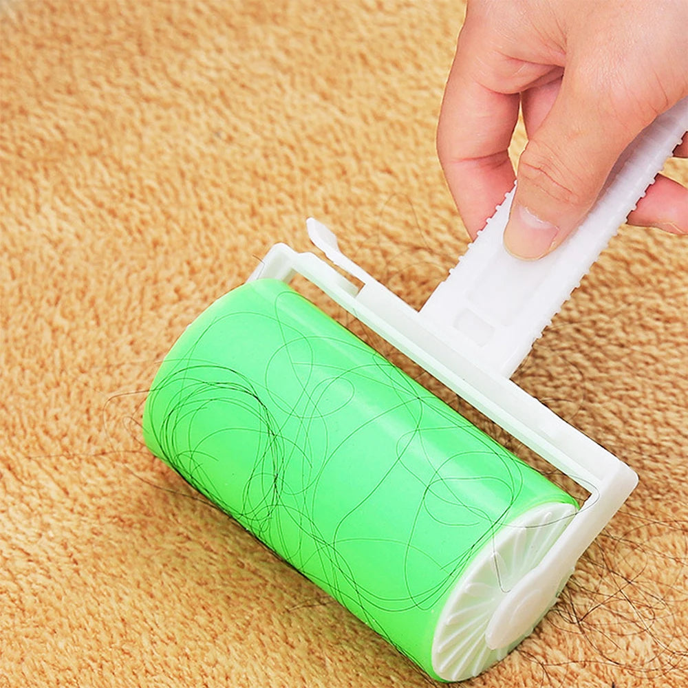 A hand uses a bright green, reusable sticky lint roller to pick up hair from a beige carpet.
