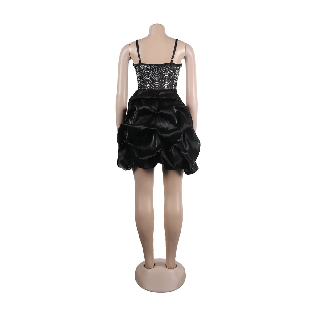 Black bodycon dress with a sheer rhinestone bodice and ruched puff skirt on a mannequin.