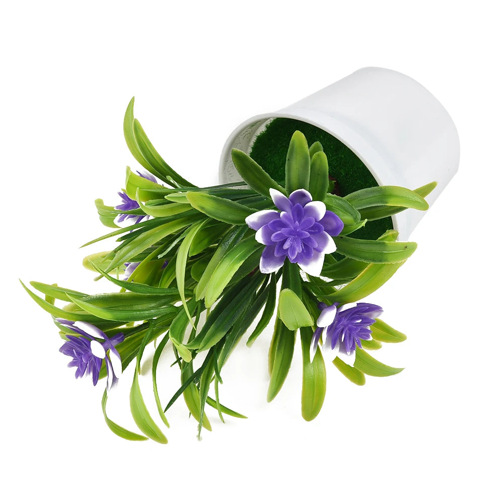 Artificial purple and white flowers with green leaves spilling out of a white plastic pot on a white background.