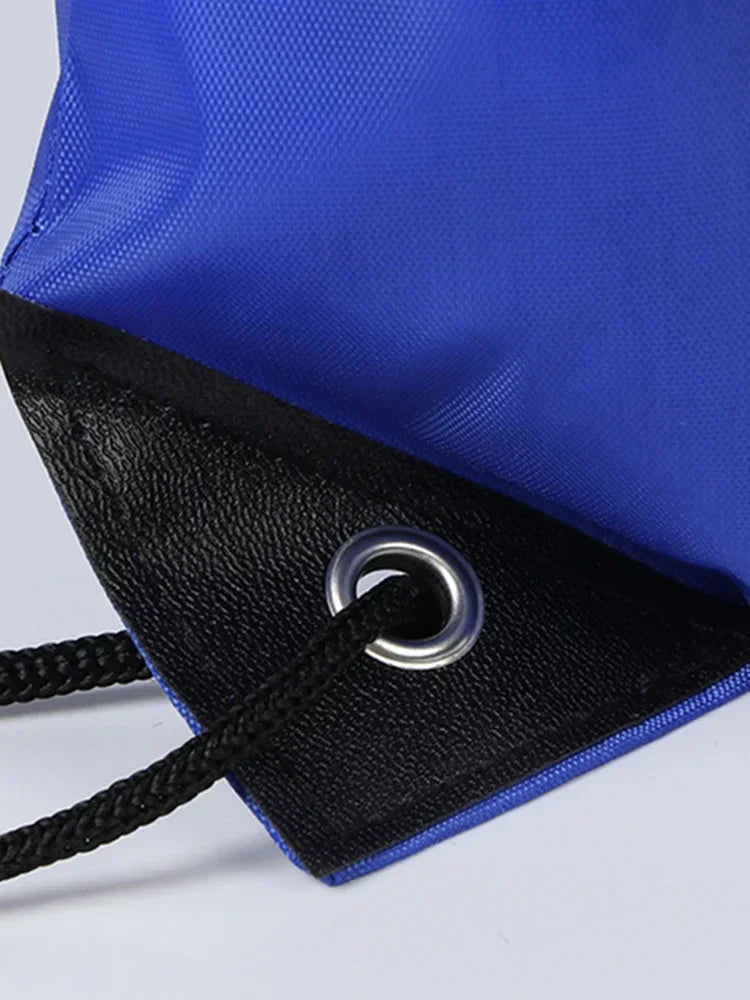 Blue drawstring bag with a black reinforced corner, silver metal eyelet, and black braided cord.