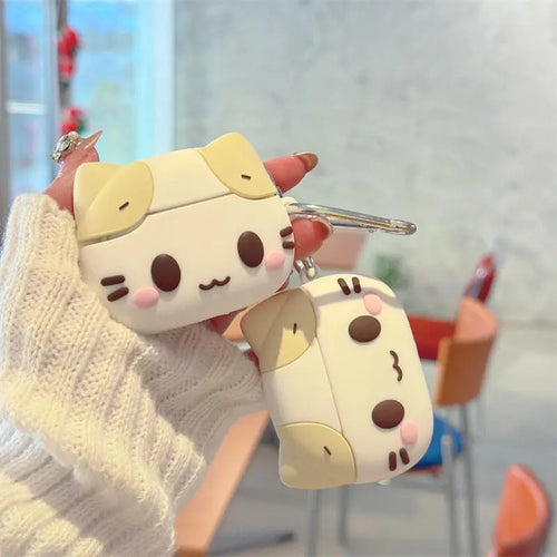 Cute cat-style silicone AirPods case in cream and beige, featuring a keychain hook.