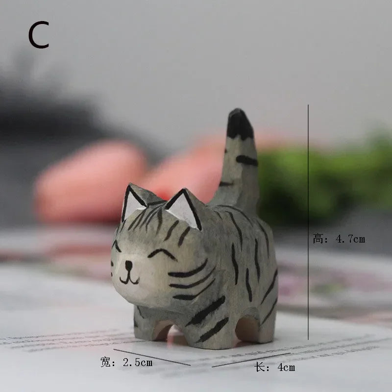 Small, hand-carved grey tabby cat figurine with painted black stripes and a happy expression.