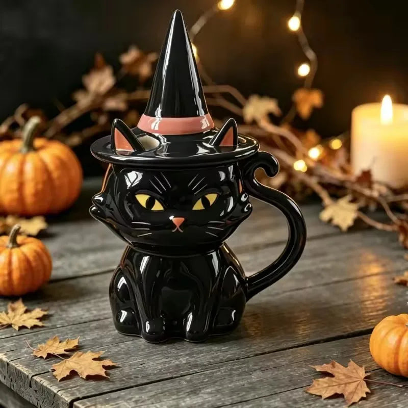 Glossy black ceramic cat mug with yellow eyes, tail handle, and a matching witch hat lid.