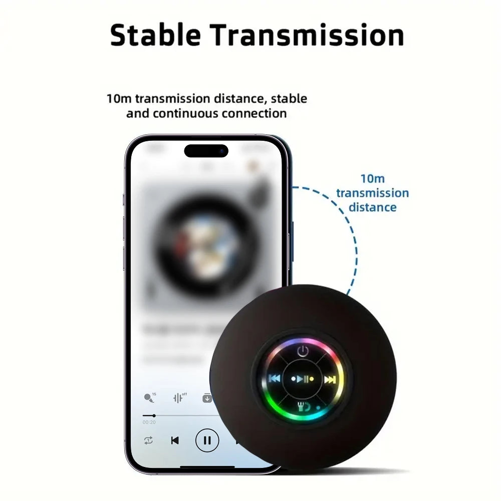 Black portable Bluetooth shower speaker with glowing LED ring and playback controls, connected to a smartphone.