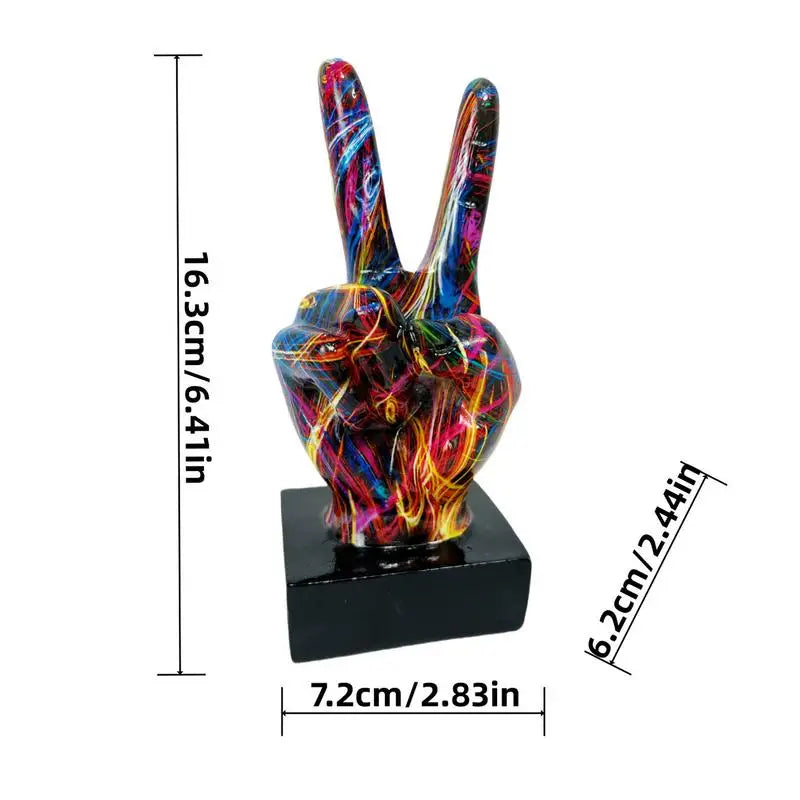 Vibrant, multi-coloured peace sign hand sculpture on a black square base. Artistic, splattered paint style.