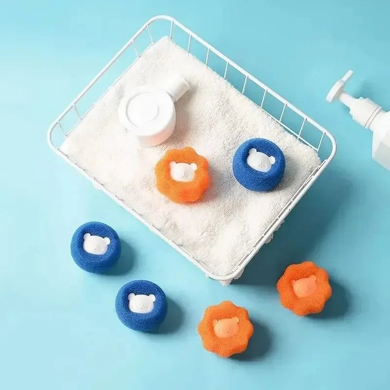 Small orange and blue bear-shaped laundry lint remover balls in a white wire basket with a white towel.
