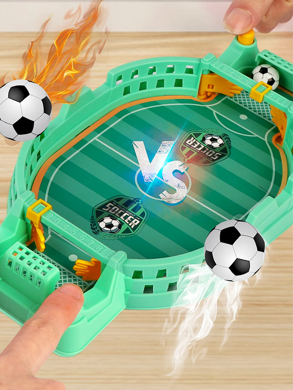 Tabletop football game in light green with yellow goalies, manual score trackers, and two miniature soccer balls.