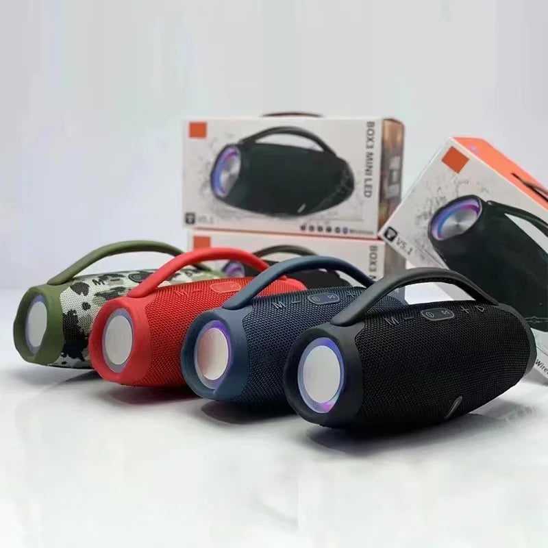 Four portable, cylindrical Bluetooth speakers in camo, red, blue, and black, featuring carry handles and RGB end lights.
