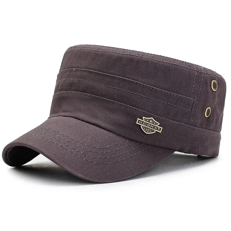 Dark brown cotton military-style flat-top cap with stitched detail, curved peak and metallic side eyelets.