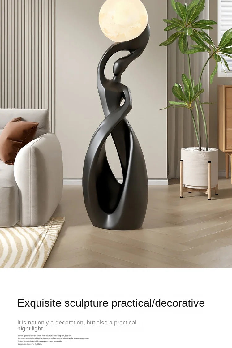 Abstract matte black resin floor sculpture featuring a curved, fluid silhouette topped with a glowing moon-like orb.