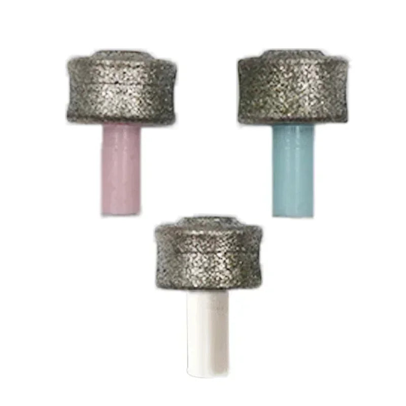 Three replacement grinding heads for a pet nail trimmer, featuring textured abrasive tops with pink, blue, and white stems.