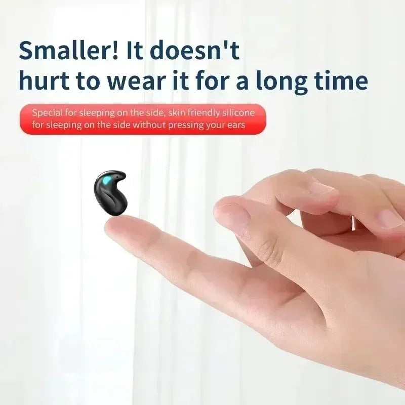 A tiny, black, comma-shaped wireless sleep earbud resting on a fingertip. Soft, ergonomic design for side sleeping.