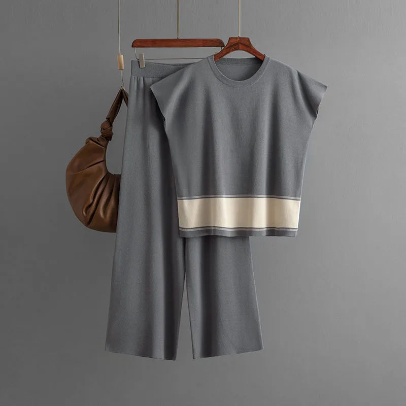 Grey knitted co-ord set featuring a short-sleeved top with a cream contrast hem and wide-leg trousers.