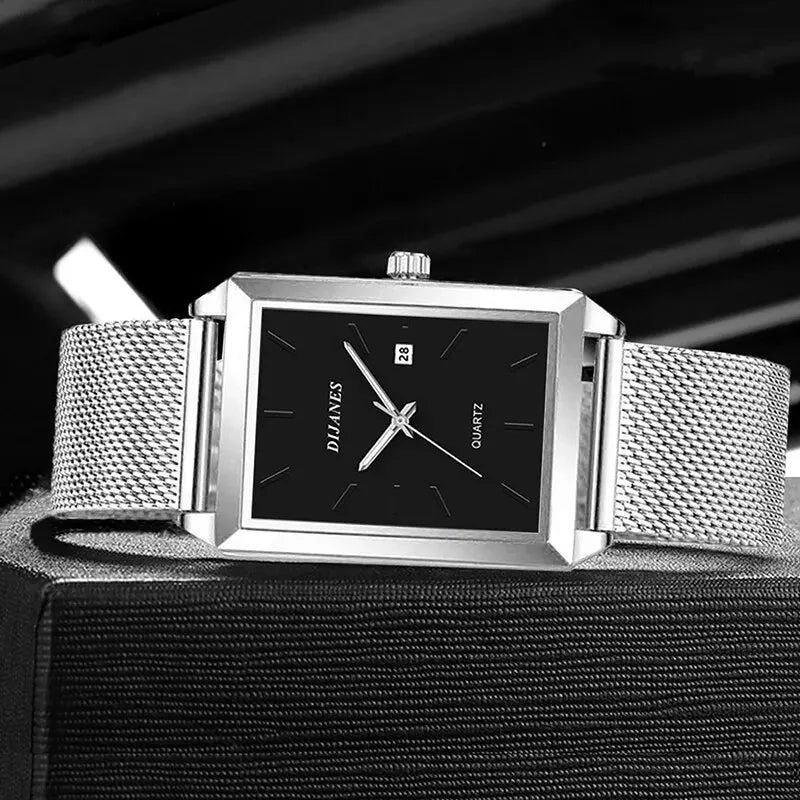 Men’s square quartz watch with a black face, date display, and polished silver stainless steel mesh strap.