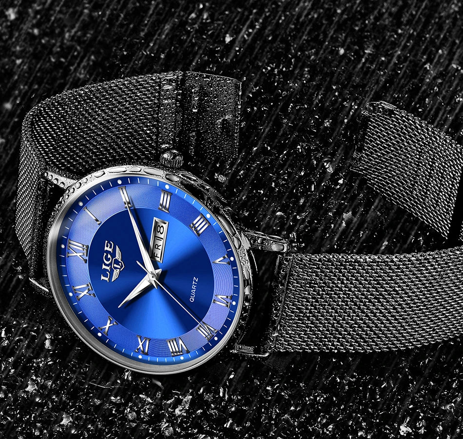 Elegant women's watch with a deep blue face, silver Roman numerals, day-date display, and black mesh metal strap.