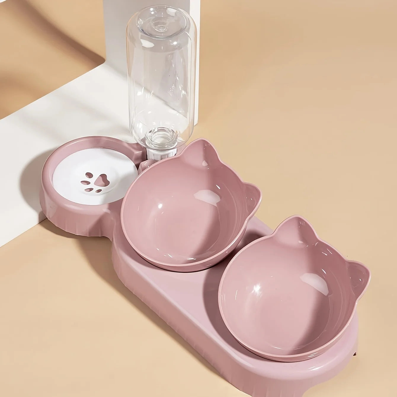 Dusty pink 3-in-1 pet feeding station with two cat-ear bowls and an integrated gravity water dispenser.