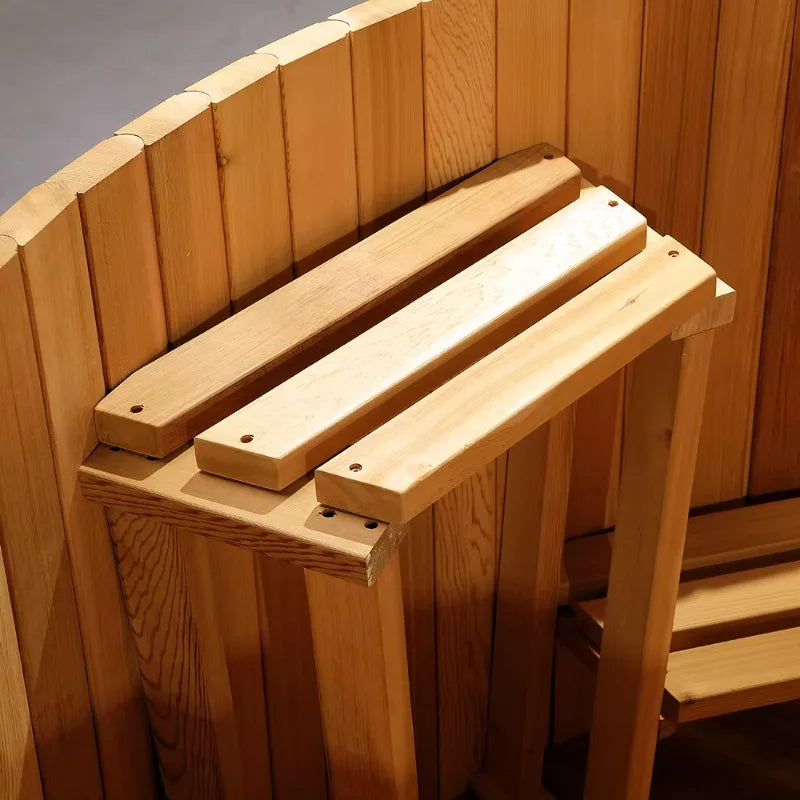 A close-up of a wooden sauna bench with slatted top and supporting legs inside a wooden room.