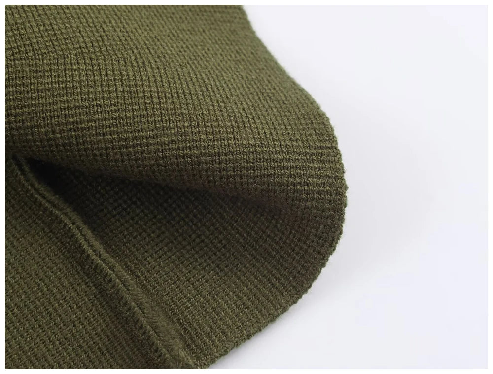 Close-up of an olive green knitted beanie showing the soft, ribbed fabric texture.