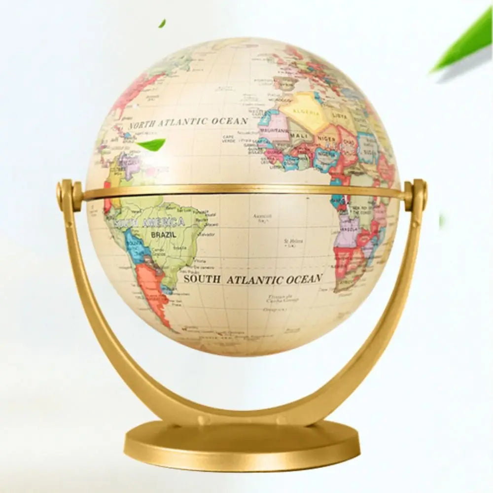 Vintage-style world globe on a gold-coloured stand, featuring a cream-toned map with multicoloured continents.