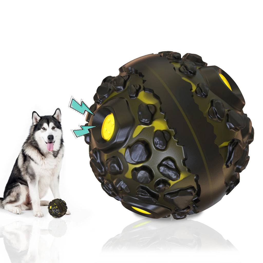 A husky sitting next to a durable, black and yellow interactive giggle ball with a textured, cratered surface.