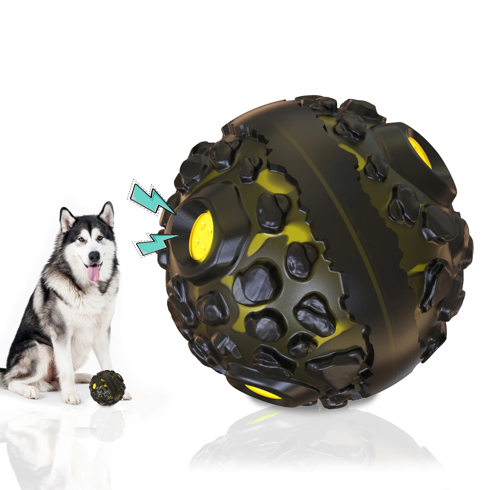 A husky sitting next to a durable, black and yellow interactive giggle ball with a textured, cratered surface.
