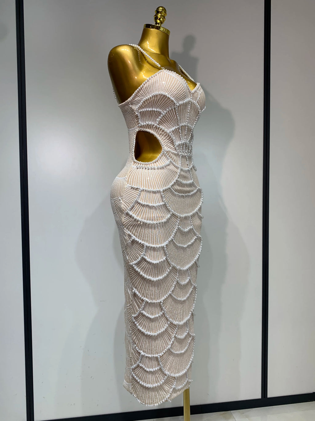 Beige maxi bodycon dress with V-neck, side cutout, and elaborate pearl beading in a scalloped pattern.