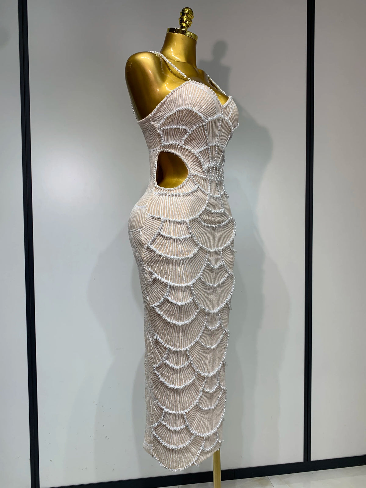 Beige maxi bodycon dress with V-neck, side cutout, and elaborate pearl beading in a scalloped pattern.