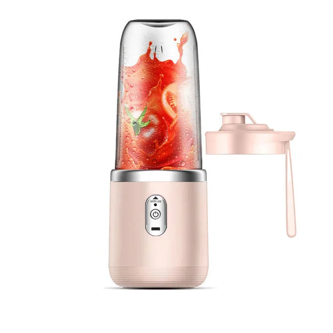 Portable light pink personal blender with a clear cup containing blended tomatoes and a separate matching lid.