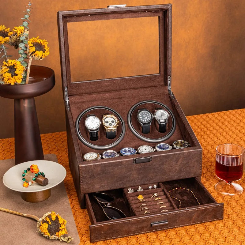 Brown leather watch winder box with glass lid, four winders holding watches, and bottom storage drawer.