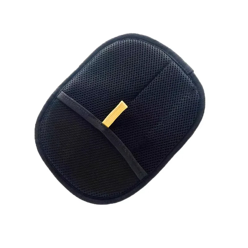 Oval black mesh tanning mitt with a yellow elastic finger strap, isolated on a white background.