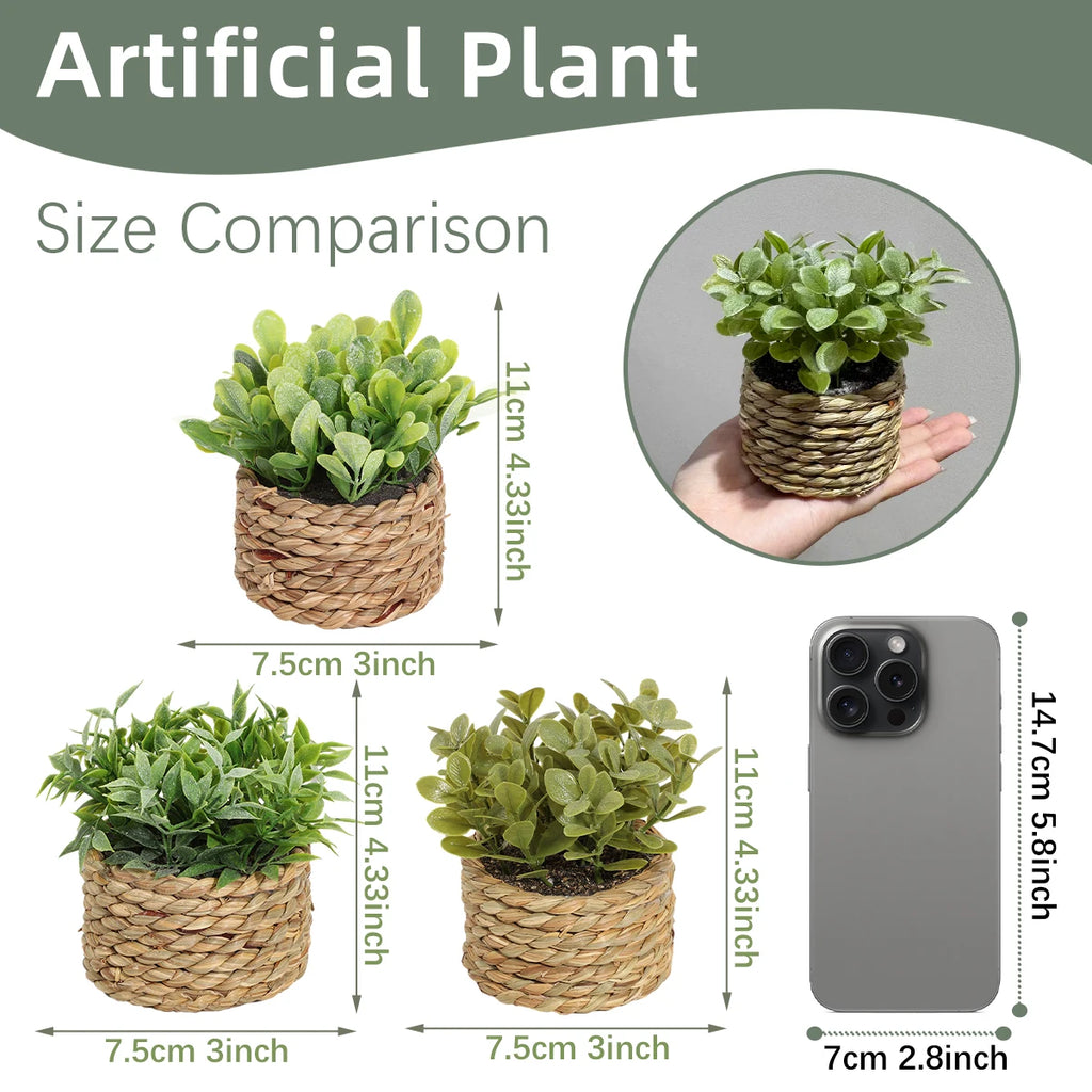 Small artificial green plants in woven seagrass pots, shown with dimensions and a smartphone for size reference.