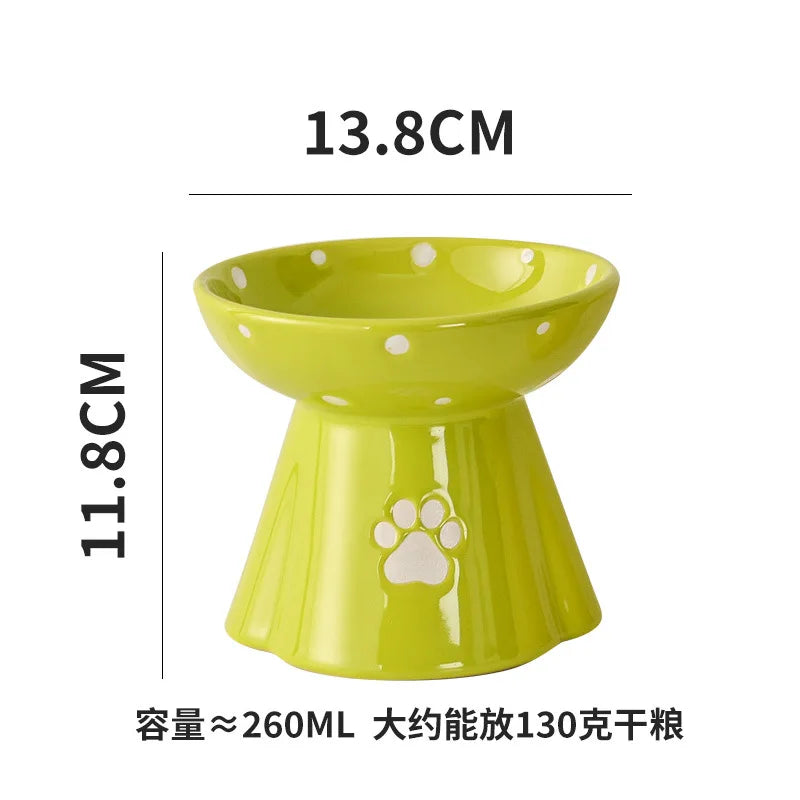 Elevated lime green ceramic cat bowl with white polka dots and a paw print design on the base.
