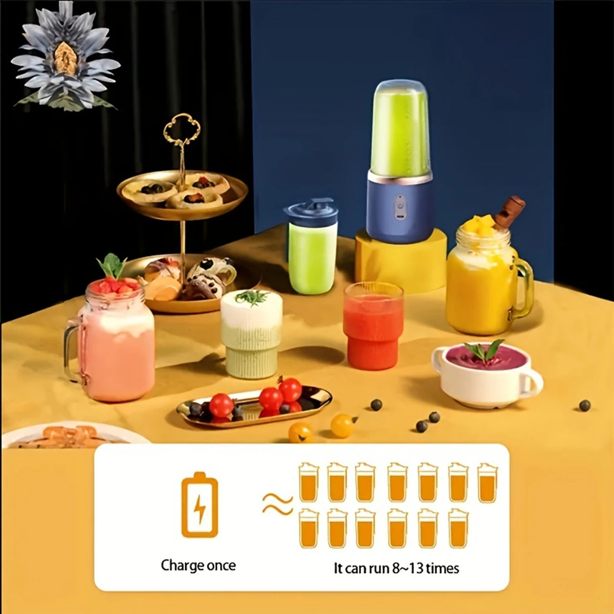 A portable, dark blue rechargeable blender surrounded by various fruit drinks, smoothie glasses, and snack platters.