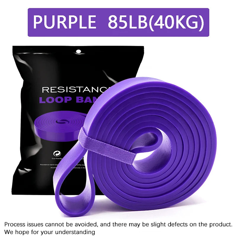 A rolled purple 85lb (40kg) heavy-duty resistance loop band in front of its black product packaging.