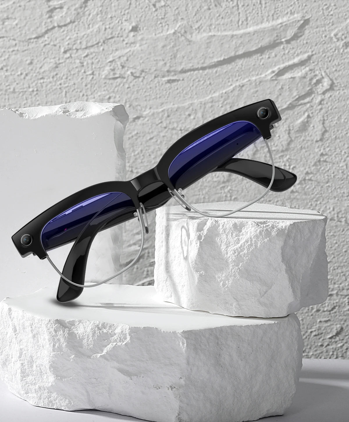 Smart AI glasses with black frames, blue-tinted lenses and integrated cameras, resting on white textured stone blocks.