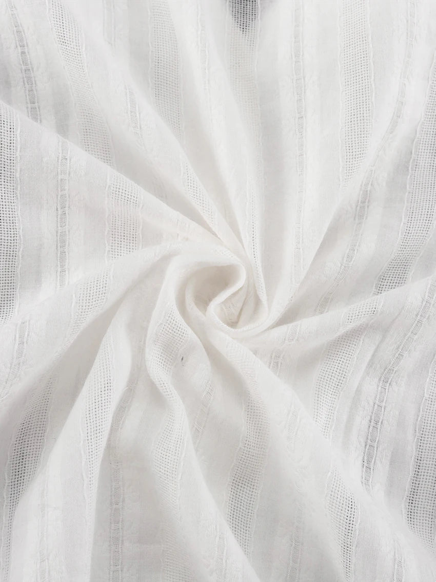 Close-up of white fabric with vertical textured stripes and a lightweight, sheer aesthetic.