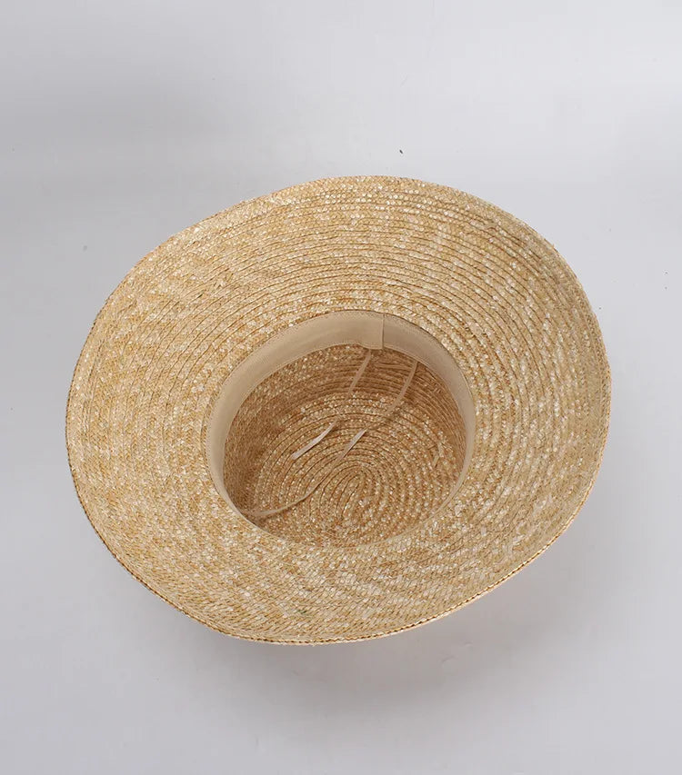 A natural straw sun hat with a wide brim, shown from above with an internal beige sweatband and adjustable tie.
