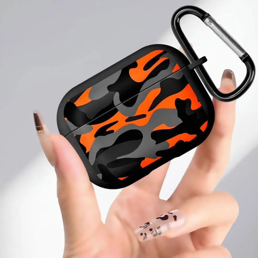 Orange, grey, and black camo print AirPods Pro case with a black carabiner clip, held in hand.