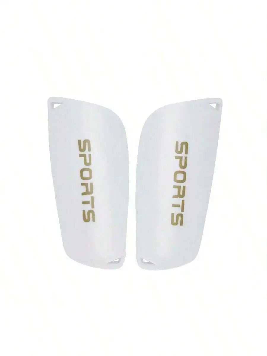 Pair of white football shin guards with gold 'SPORTS' text, featuring a contoured, lightweight protective design.