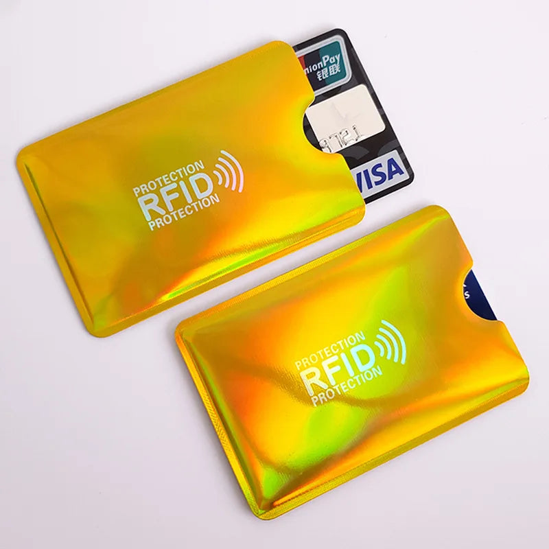 Two metallic gold, holographic RFID-blocking credit card sleeves with thumb cutouts for easy card removal.